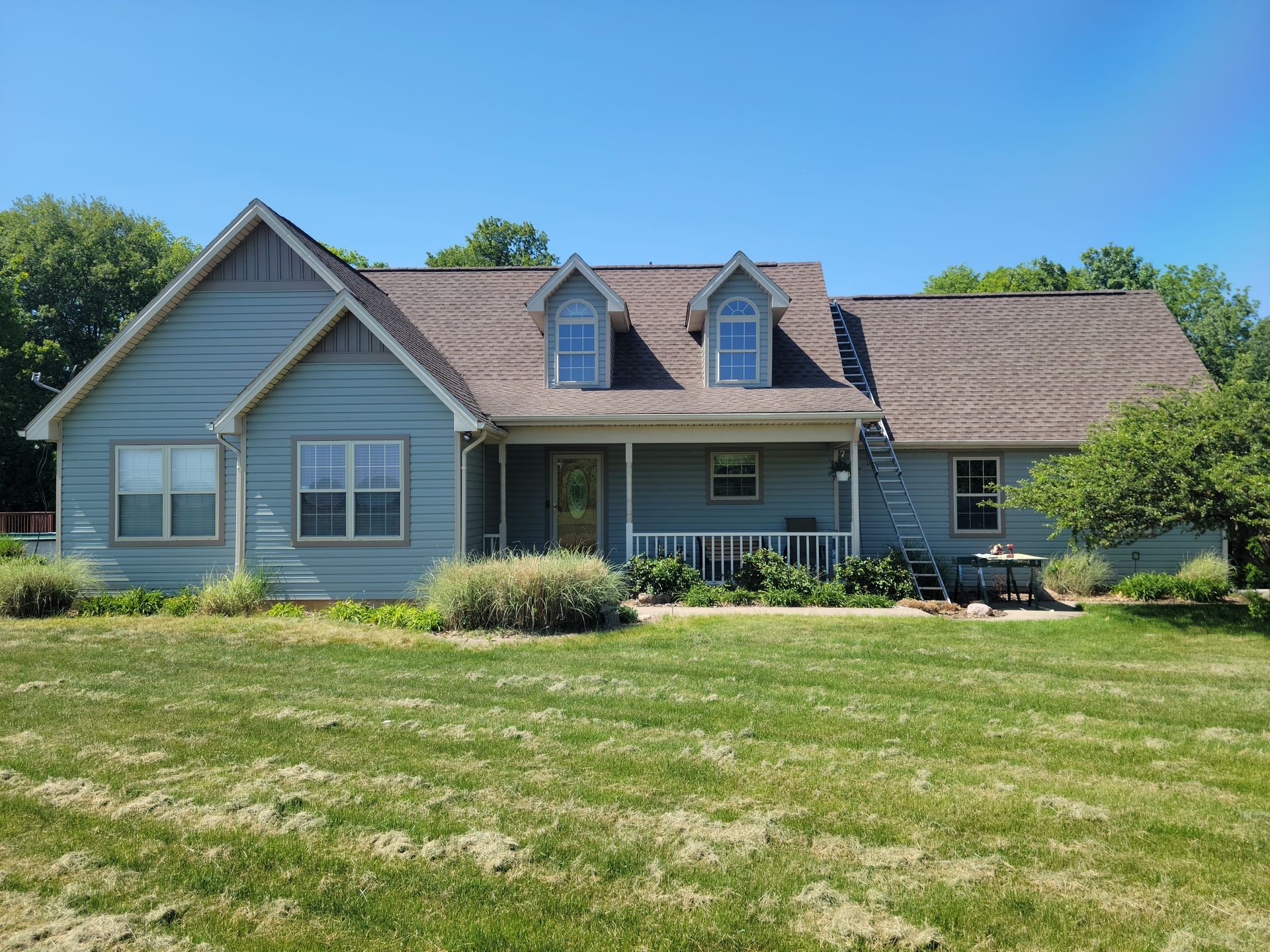 White-trimmed windows and two dormer windows on a blue-gray home