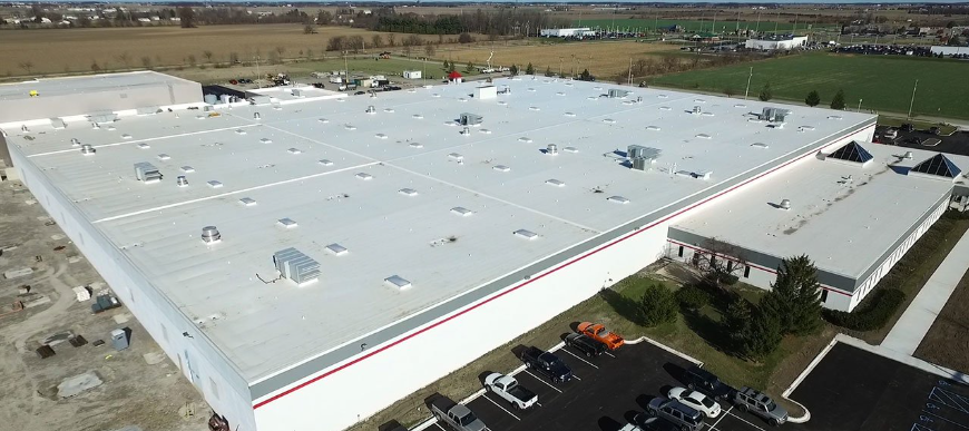  Aerial view of a warehouse with a newly installed roofing system