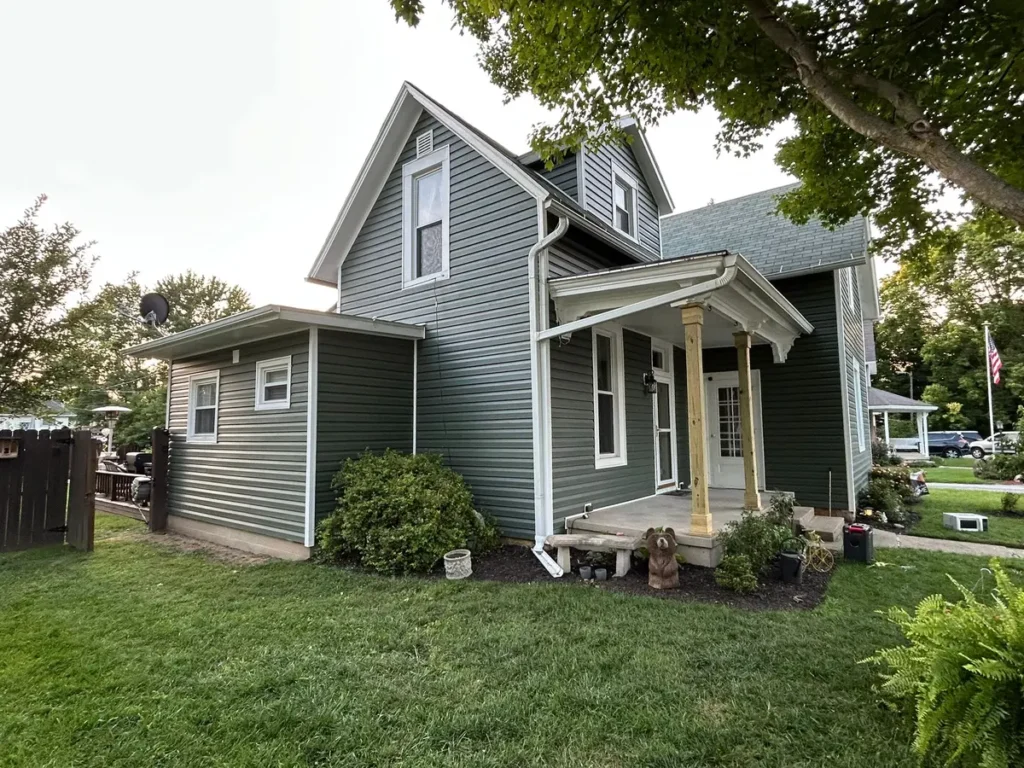 White-trimmed windows on a gray-sided Delphi home with a covered front porch