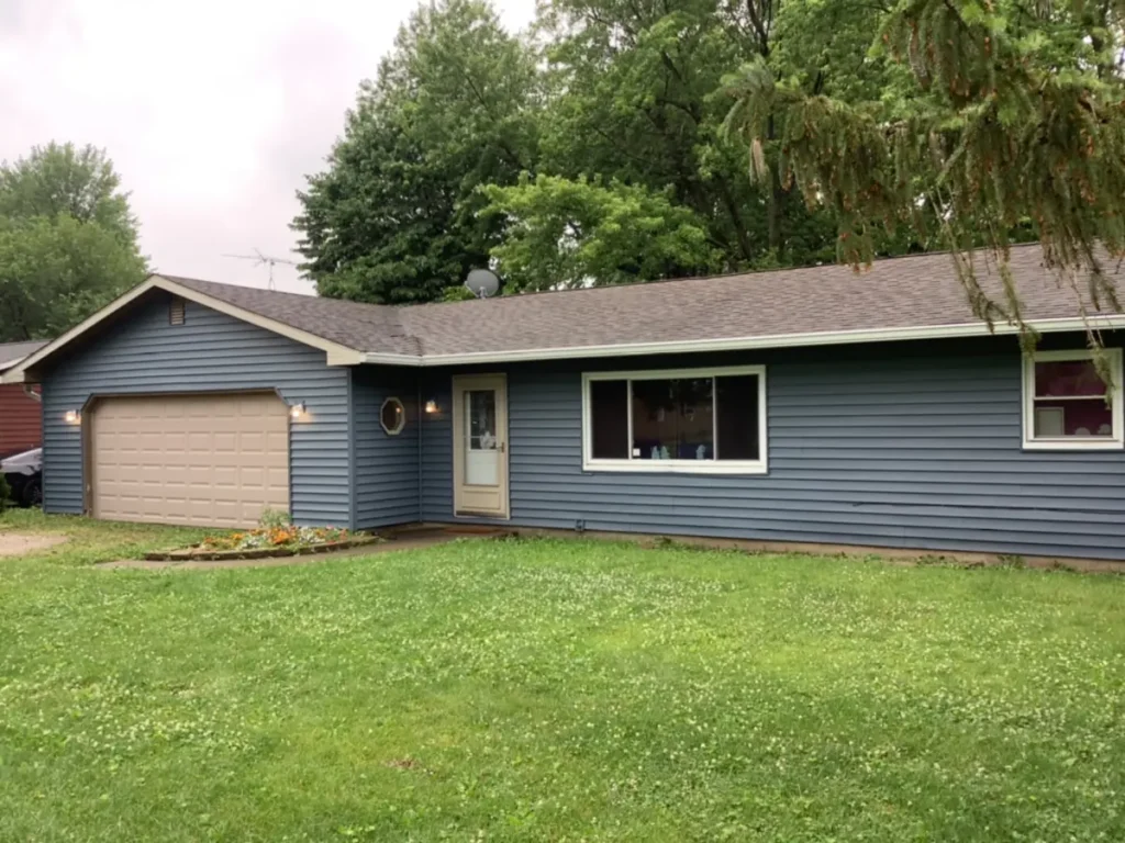 Wide front window on a single-story Otterbein home with blue siding and an attached garage
